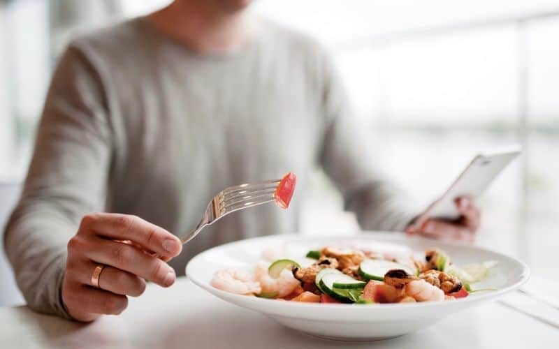 A person eating a meal on a white table.