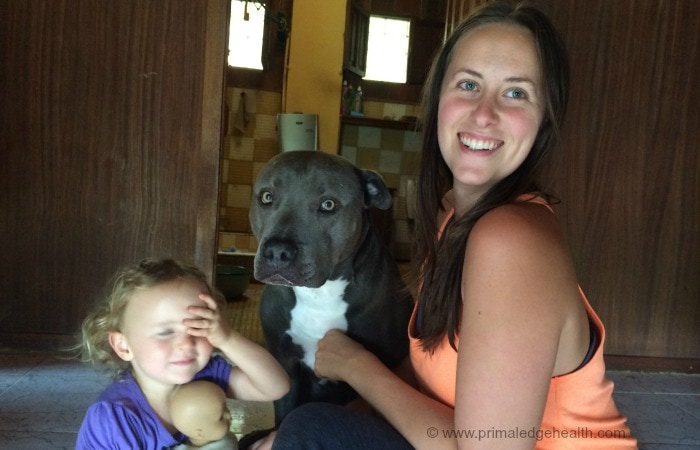A woman in ketosis next to a pet dog and a child smiling to the camera.