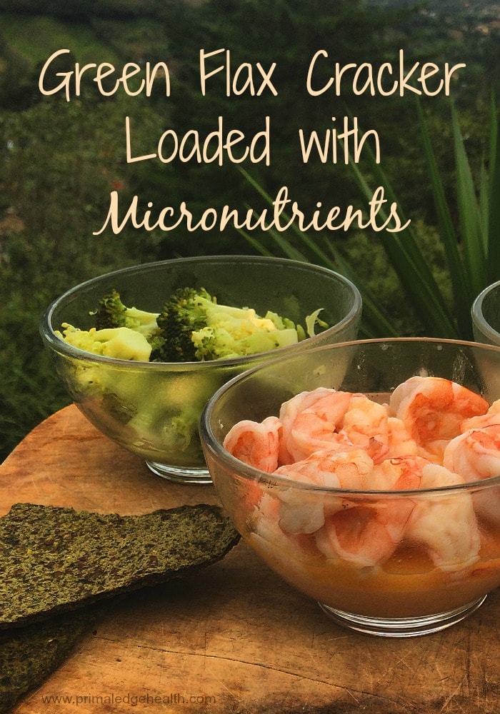 Green flax cracker loaded with micronutrients. A bowl of broccoli and a bowl of shrimps next to each other.