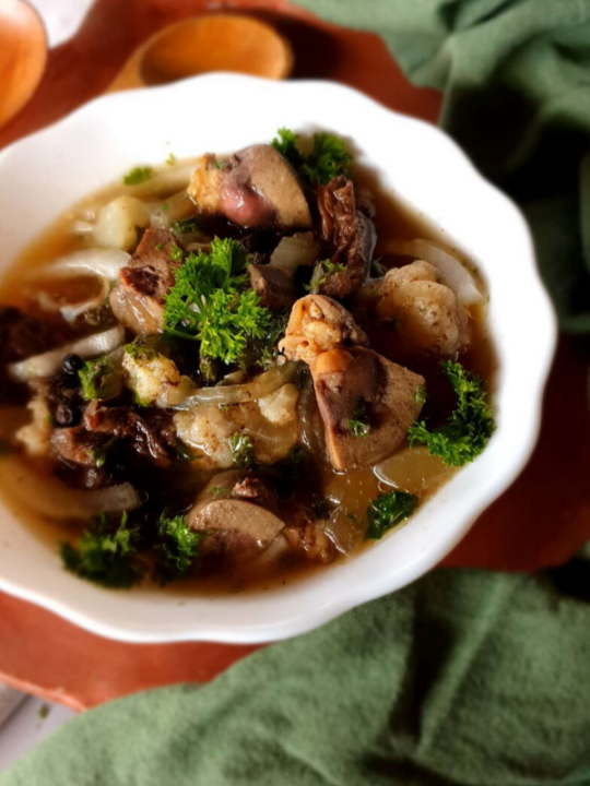 Organ meat stew in a white bowl.