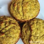 Three pieces of savory muffins on a white surface.