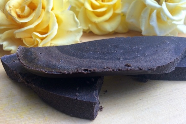 A stack of mint chocolate bar next to yellow flowers.