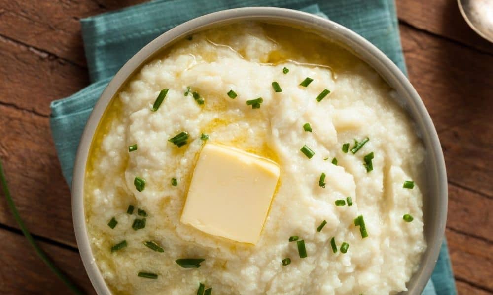 Mashed potato in a bowl with a slice of butter.