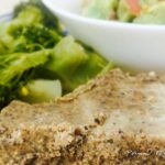 A slice of pemmican with vegetables in the background.
