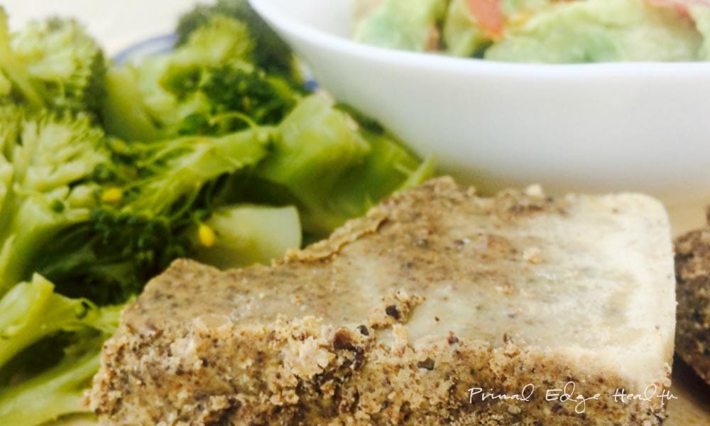 A slice of pemmican with vegetables in the background.