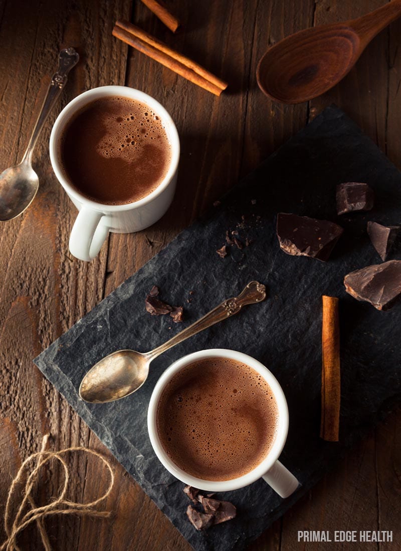 Servings of keto hot chocolate on a wooden surface.