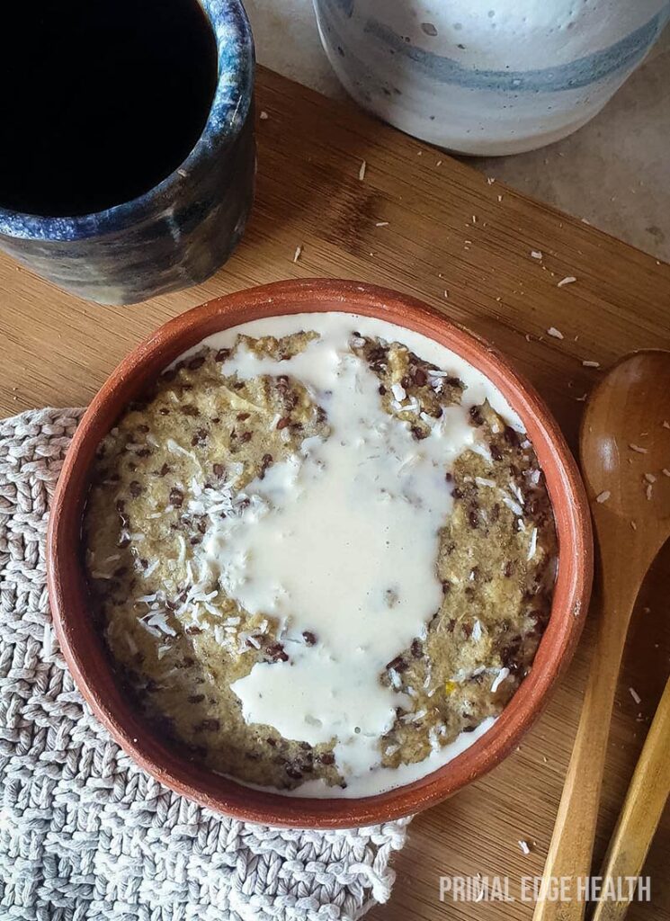 Hot keto cereal in a bowl served on a wooden board with wooden spoons.