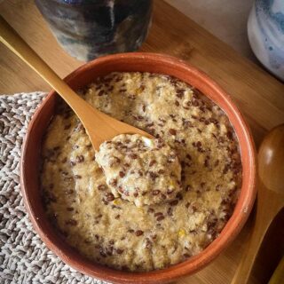 Hot keto cereal served in a brown bowl with a wooden spoon.