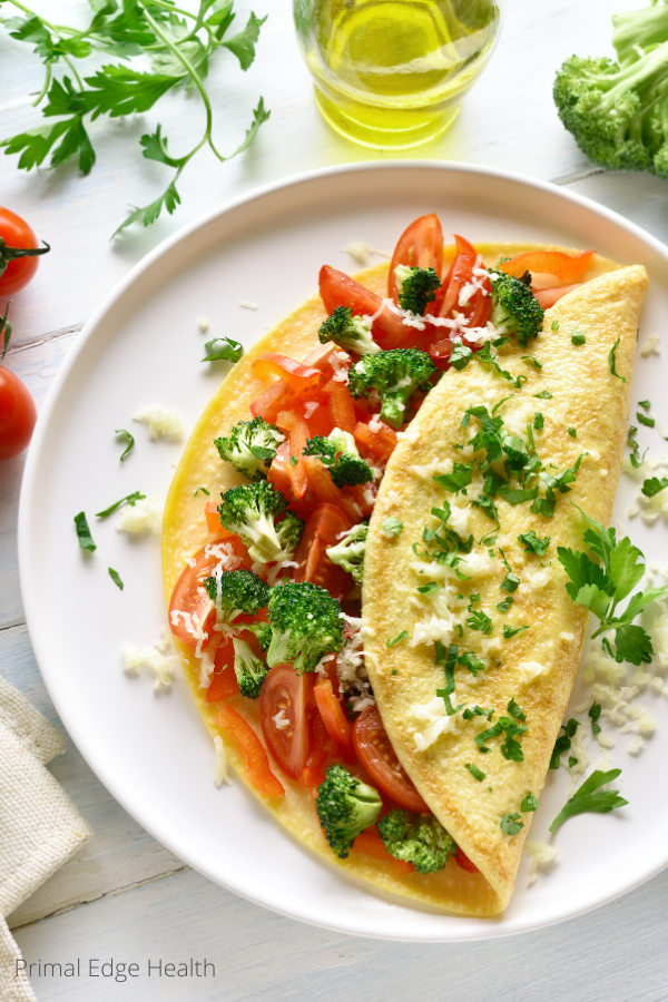 Omelette with broccoli and tomatoes on a plate.