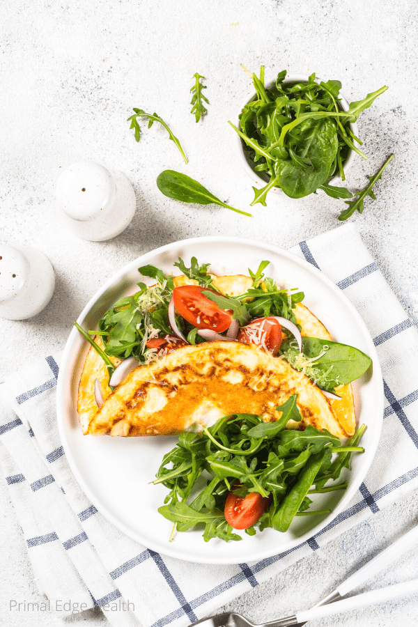 Omelette with vegetables on a white plate.