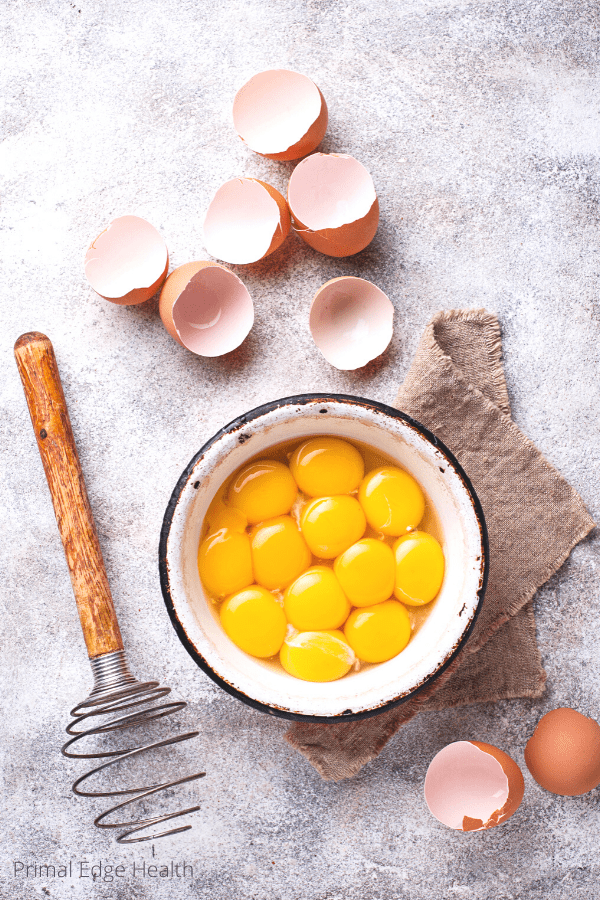 Organic eggs in a white bowl ready to be beaten for omelette recipe.