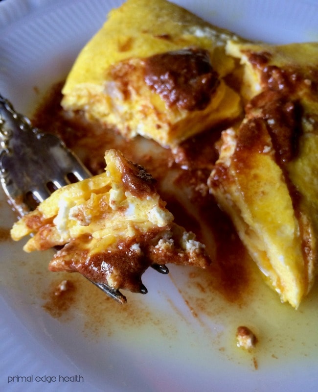 A fork full with snickerdoodle omelette being raised from the plate.