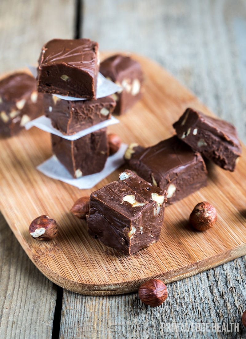 Pieces of Keto Nutella Fat Bombs on a wooden board on a wooden surface.