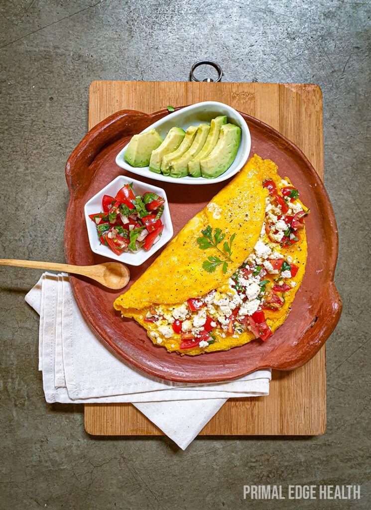 Mexican omelette served on a plate with a wooden spoon on a wooden board.
