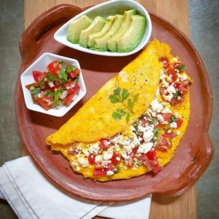 Mexican omelette on a brown plate on a wooden board.