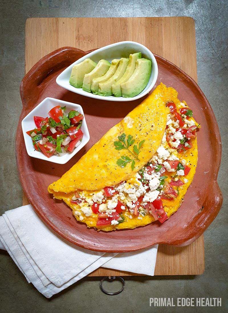 Mexican omelette on a brown plate on a wooden board.