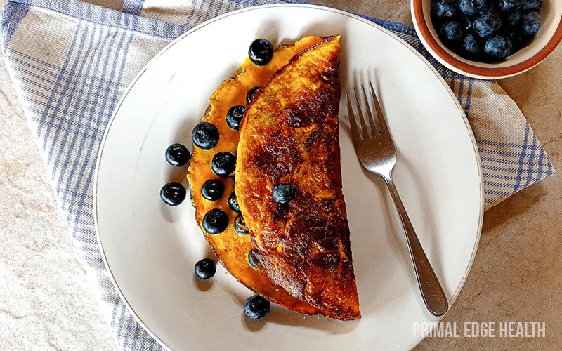 Sweet omelette with blueberries served with a fork.