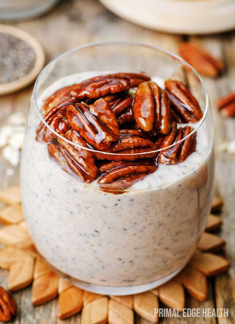 Chai latte chia pudding in a glass on a wooden surface.