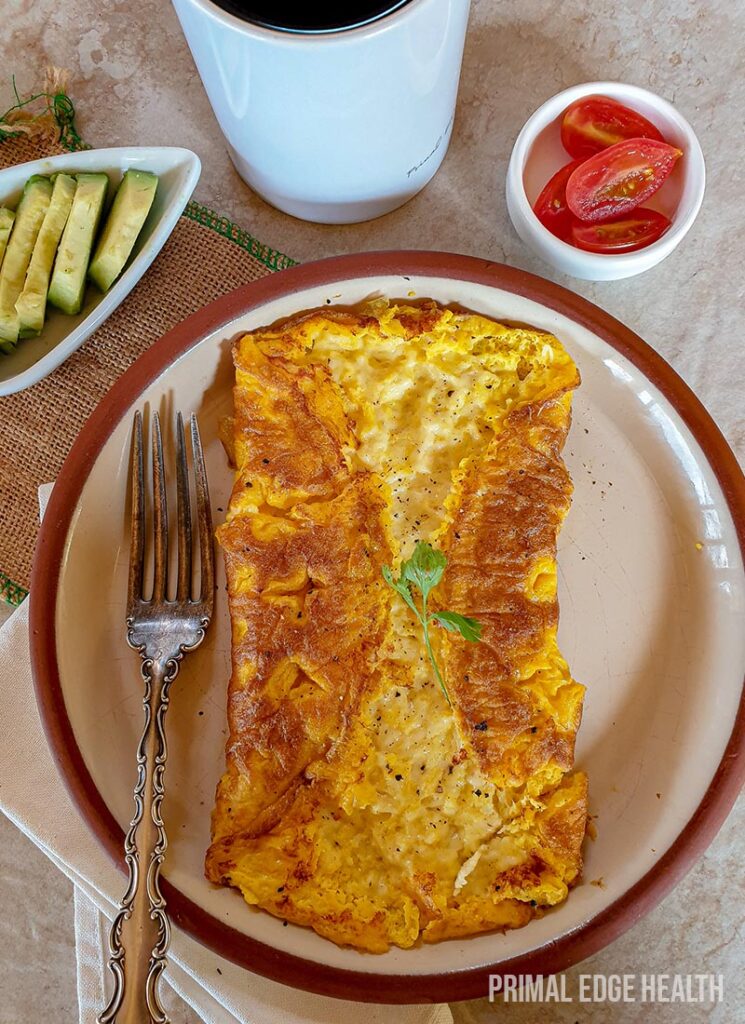 A plate of three cheese omelette served with a fork.