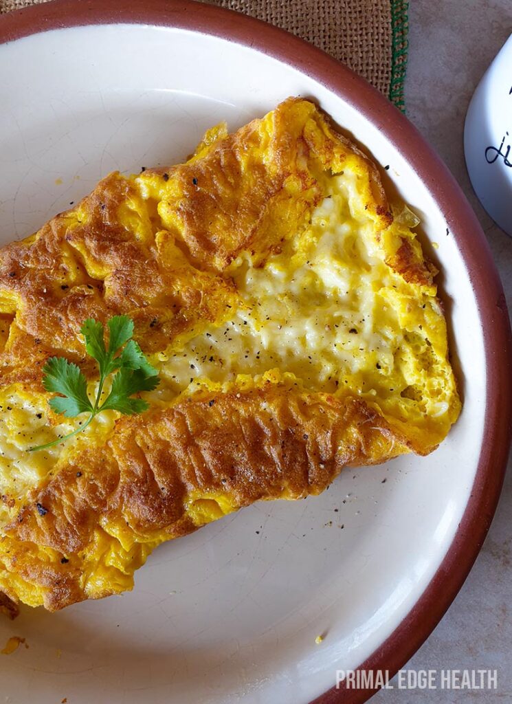 Three cheese omelette on a white plate.