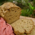 The best psyllium husk keto bread recipe on a wooden board with a view of nature at the background.