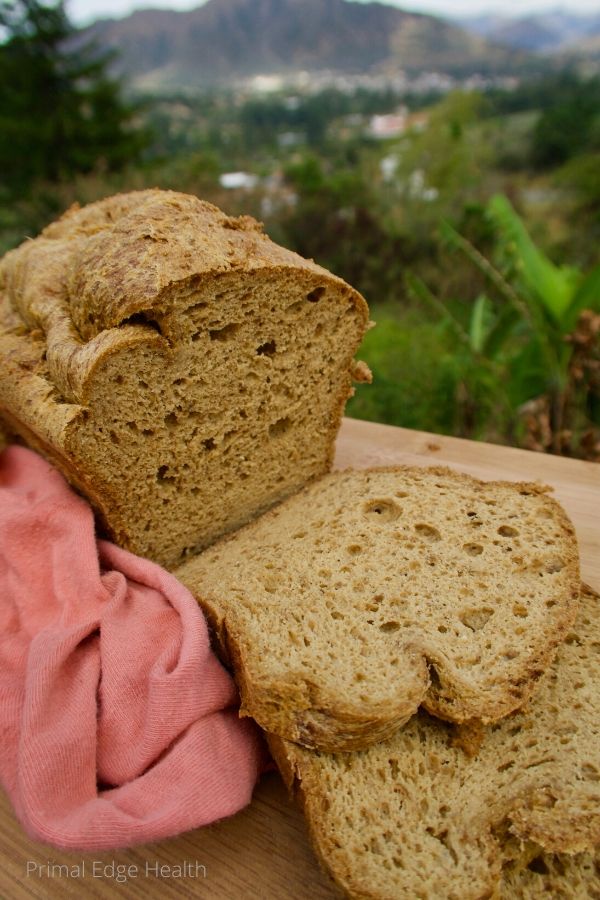 The best psyllium husk keto bread recipe on a wooden board with a view of nature at the background.