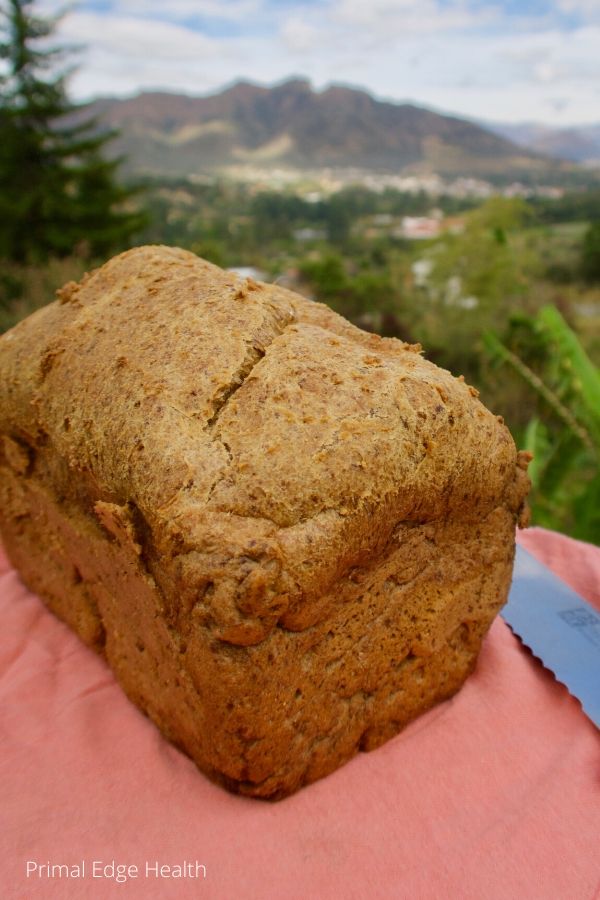 A whole loaf of keto bread on a red surface.