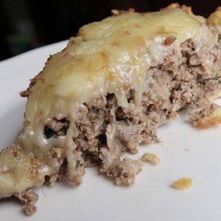 A slice of beef heart keto meatza on a white plate.