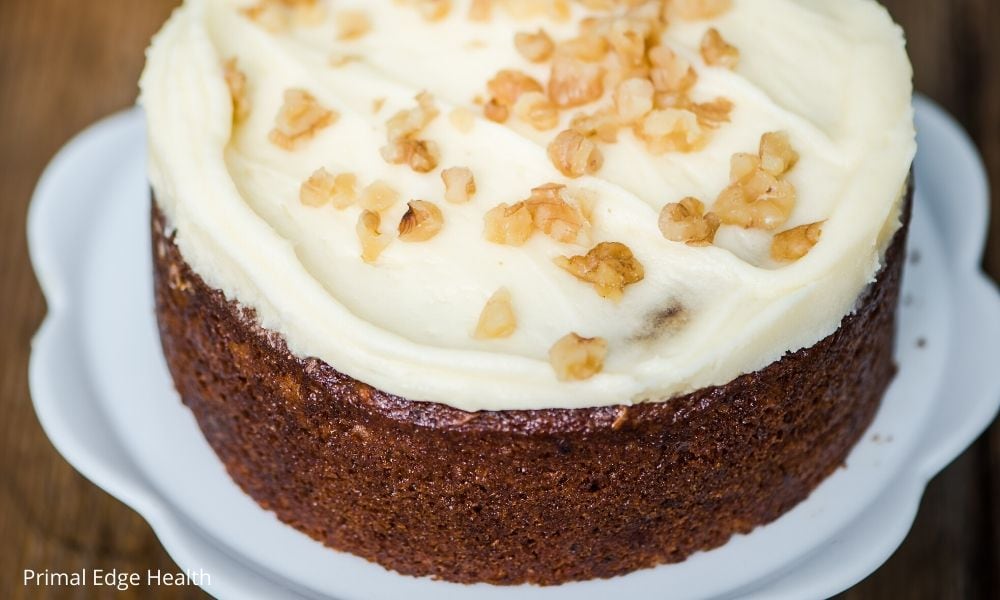 Keto carrot cake with cream cheese frosting and walnut pieces.