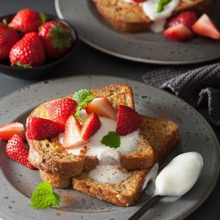 A plate of keto French toast with strawberries and cream.