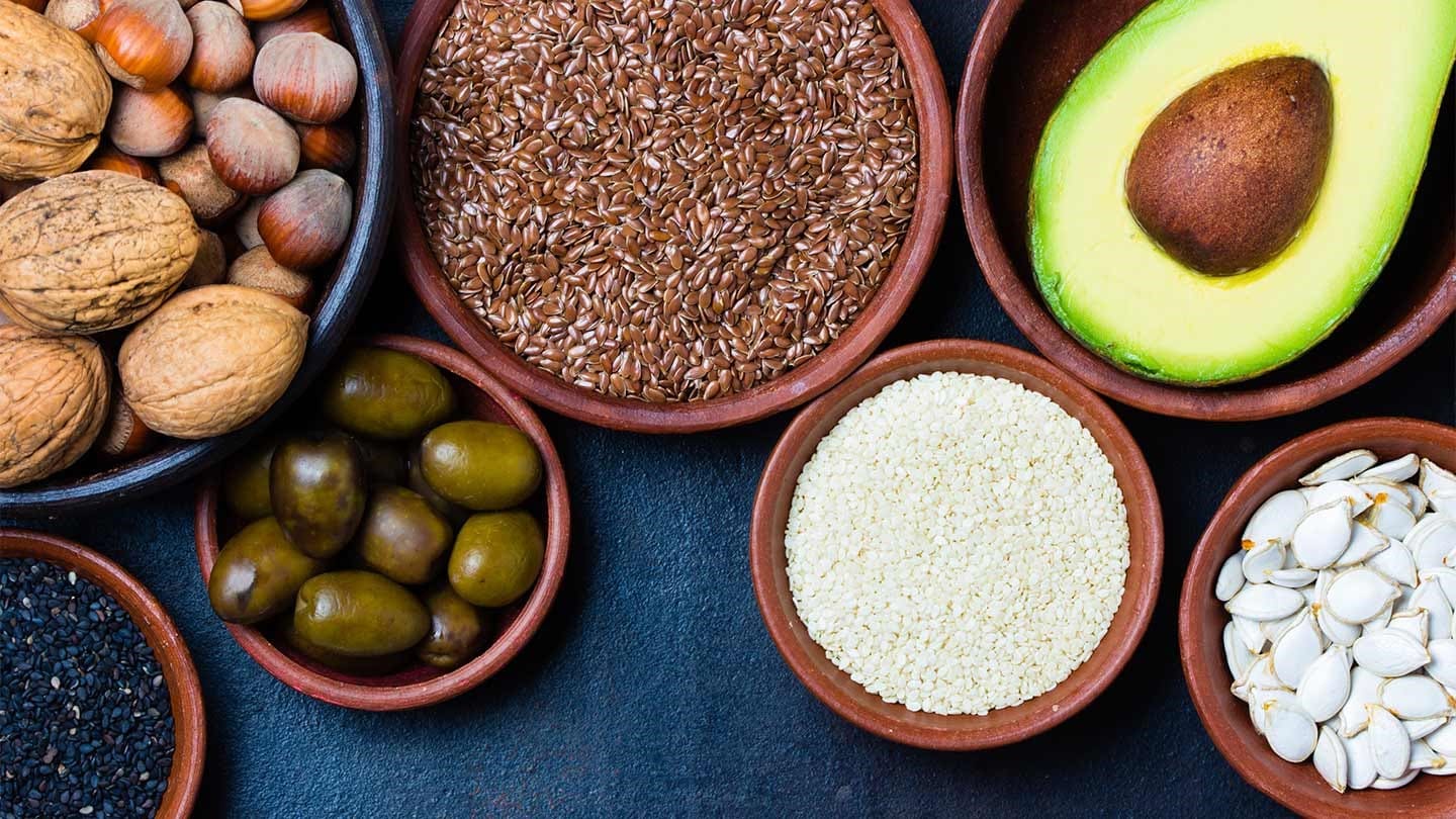 Different fresh ingredients in separate bowls with blue background.