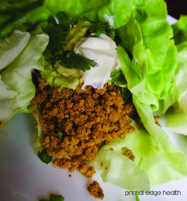 Lettuce wraps with turmeric-infused ground beef on a white plate.