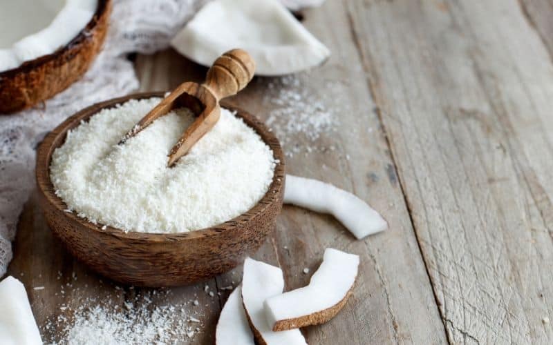 Shredded coconut flakes in a brown bowl.