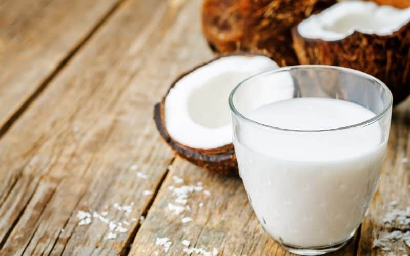 A glass of coconut cream on a wooden surface.