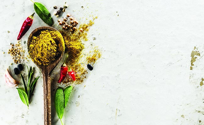 Spices and herbs on a wooden spoon for sale.