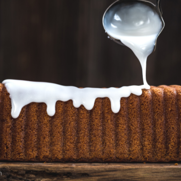 Dairy free icing keto sugar free glaze on bread on a wooden board.