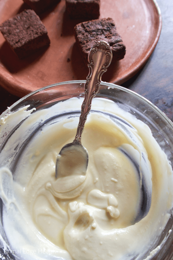 Easy keto frosting on a glass bowl with a spoon.