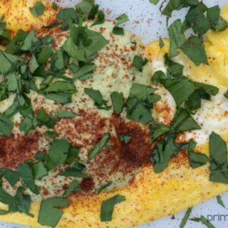 Omelette with garnish on a white surface.