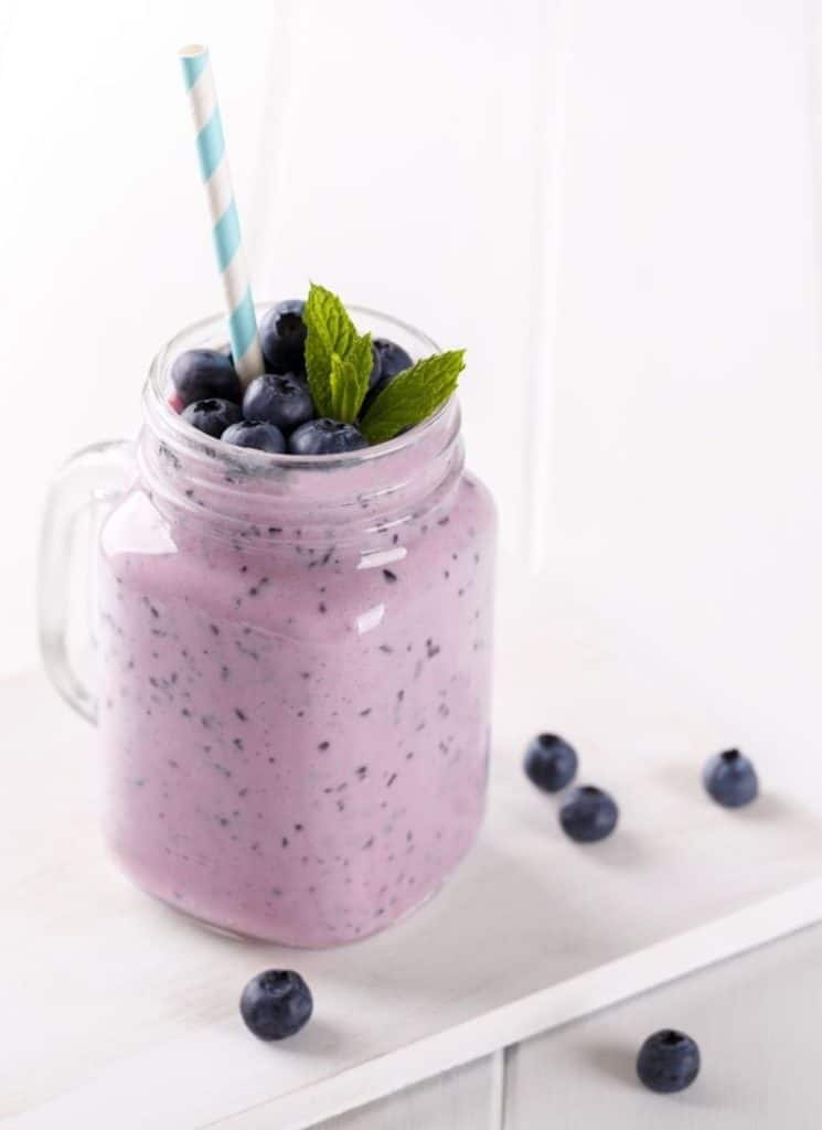 Avocado berry smoothie recipe garnished with blueberries.
