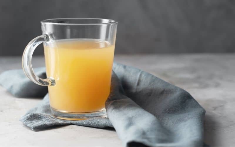 Bone broth in a clear mug.