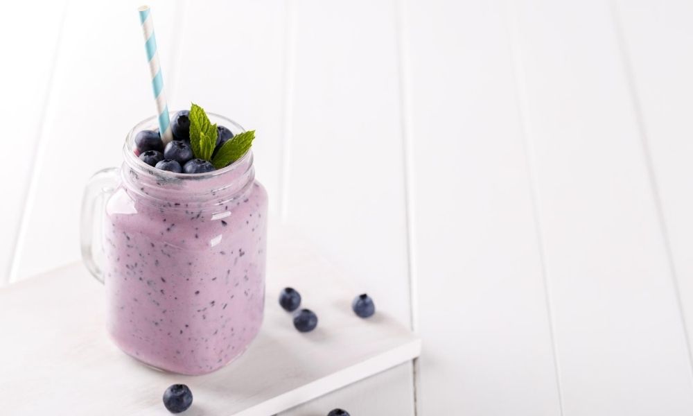 Low-carb avocado smoothie recipe on a white wooden surface.