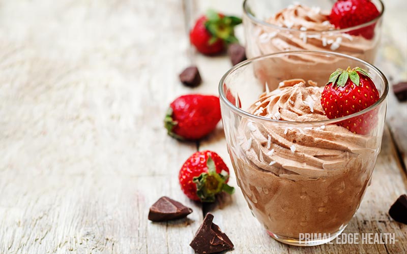 Glasses of keto chocolate mousse garnished with strawberries.
