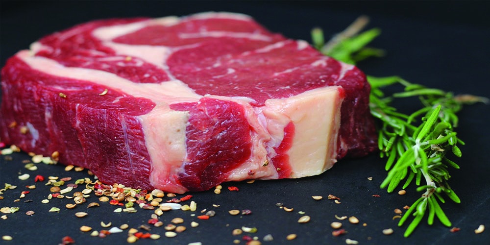 Raw meat garnished with spices and herbs.