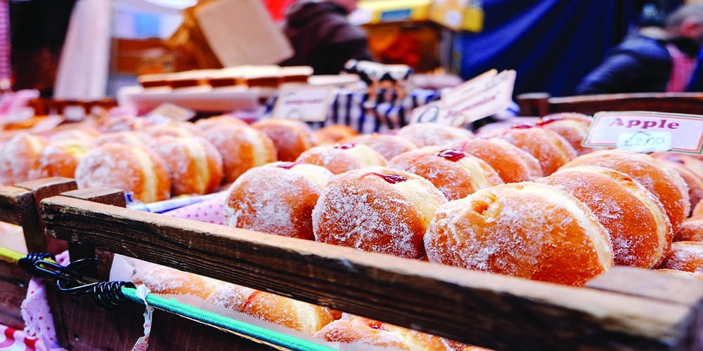 Trays of donuts in a shop.