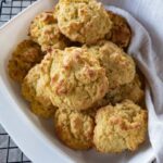 A white dish of keto drop biscuits on a wire cooling rack.