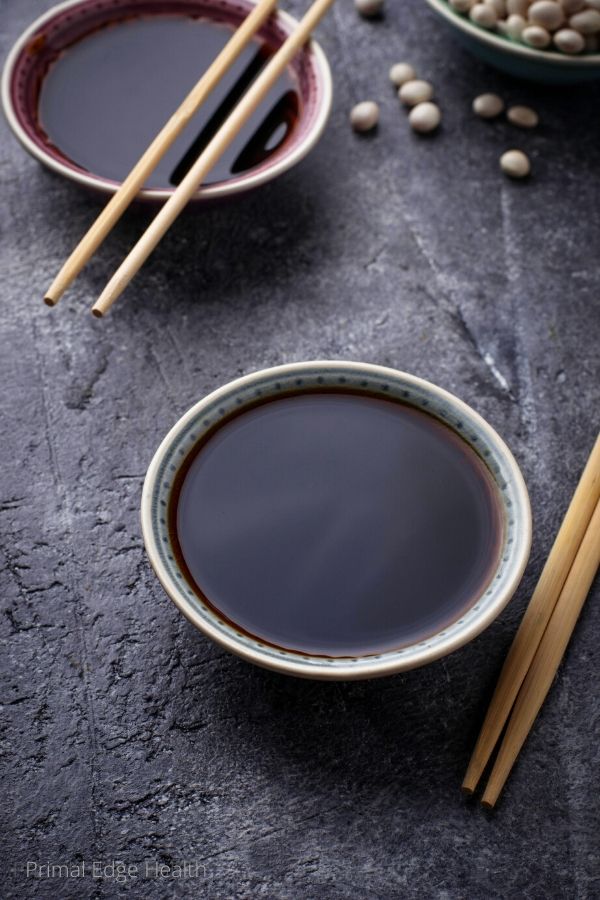 Two small bowls of keto friendly soy sauce on a grey surface.