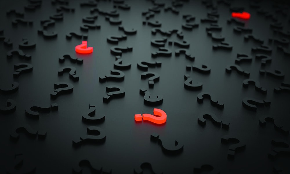 Three glowing red question marks surrounded by black question marks.