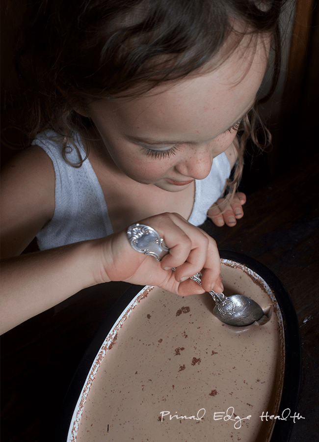 A child taking a spoon of no-bake eggnog cheesecake.