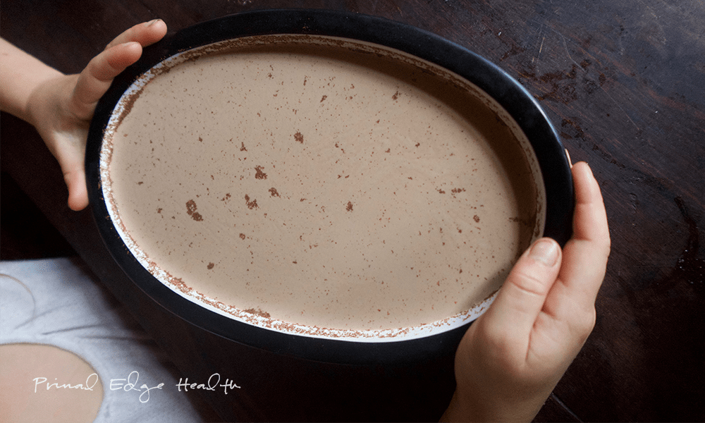 A child holding a dish full of no-bake eggnog cheesecake.