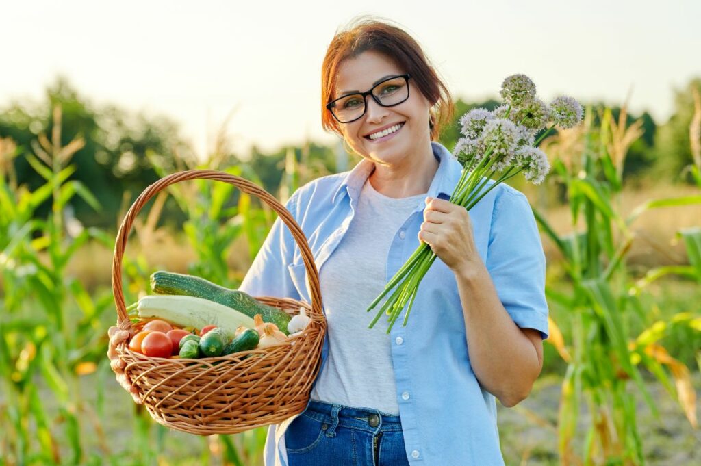 A woman holding a basket of vegetables, demonstrating the joy found in fresh local foods.
